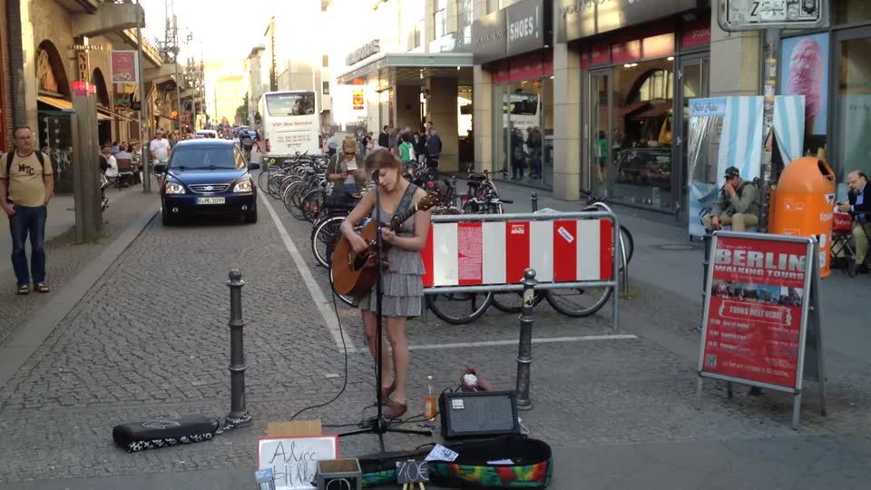 A street musician with a guitar on a pedestrian street in Berlin